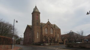 Colour photograph of sandstone church, showing two sides.